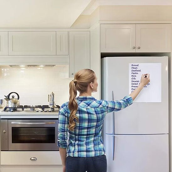 femme ecrit liste courses tableau magnetique frigo cuisine