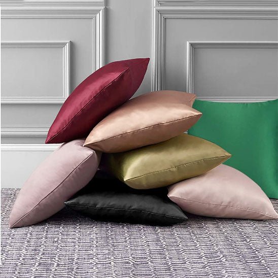 housse de coussin multicolore empilee devant mur gris