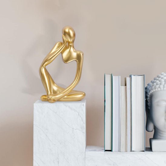 sculpture abstraite doree personnage assis decoration