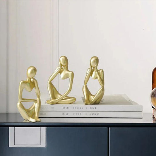 sculpture abstraite doree personnages assis decoration