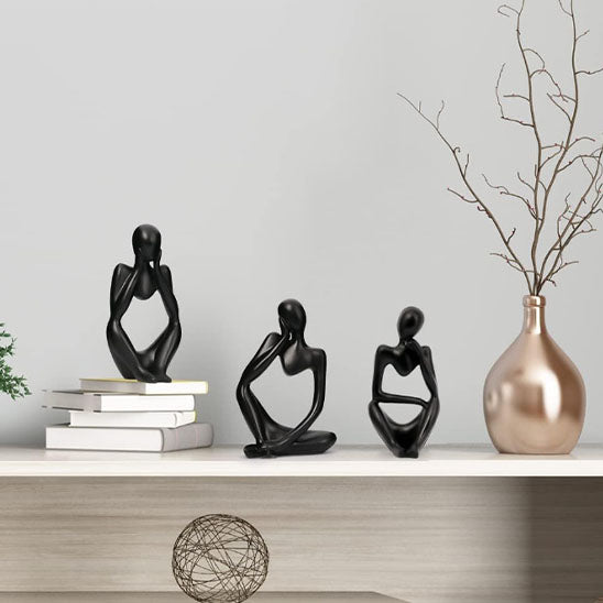 sculpture abstraite noire personnages assis ligne moderne