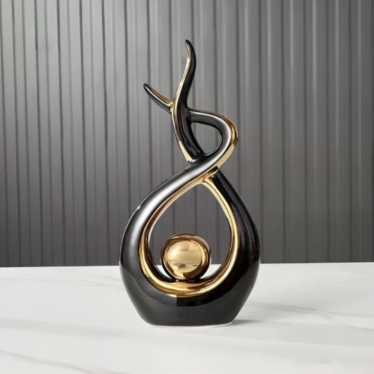 sculpture decorative noire et or sur fond gris