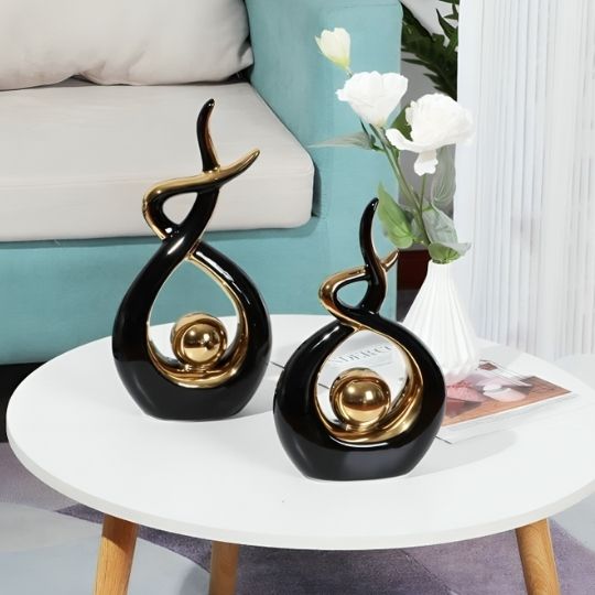 sculpture decorative noire et or sur table blanche