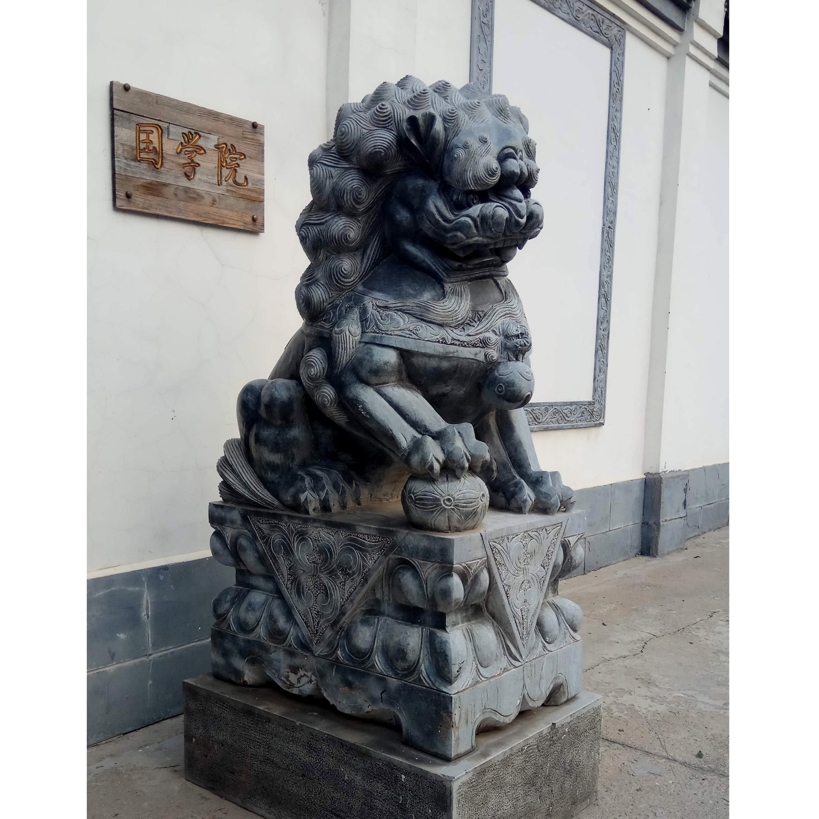 sculpture lion gardien chinois en pierre sur socle traditionnel