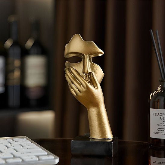 sculpture visage abstrait dore main sur bouche