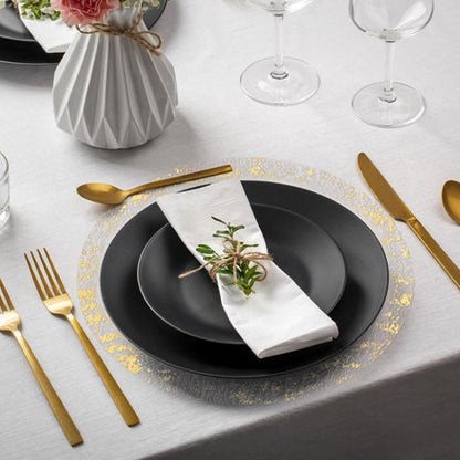 set de table rond assiette noire serviette blanche couverts dores